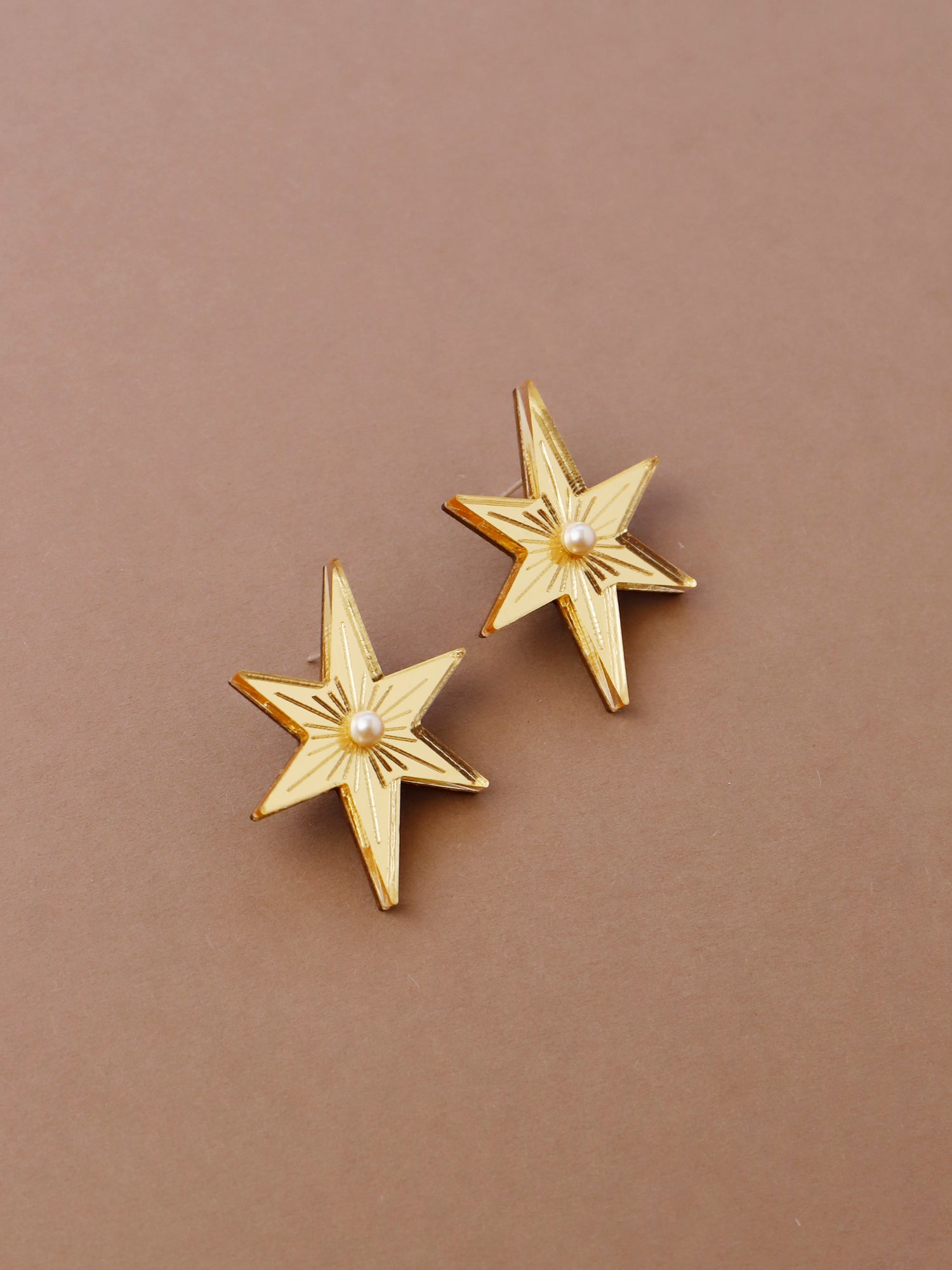 Statement star studs made with gold mirrored acrylic, embellished with glass pearls and hand inked details. Handmade in London by Wolf & Moon.